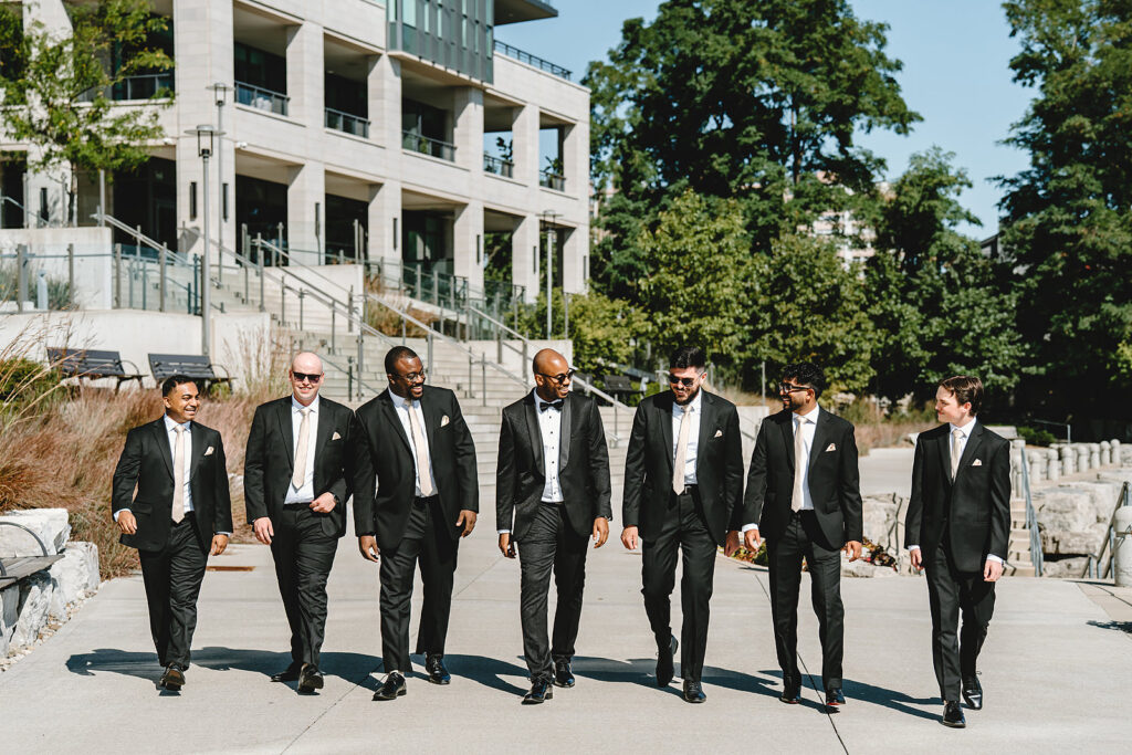 A groom and groomsmen walking outside The Pearle Hotel