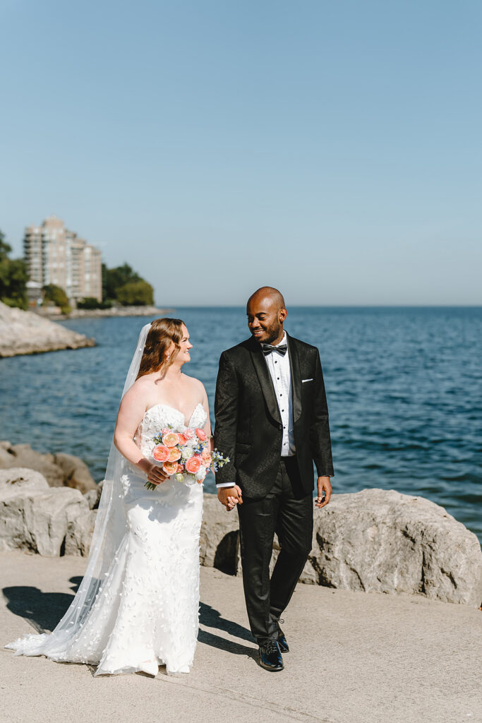 Newlyweds walking by lake ontario at The Pearle Hotel