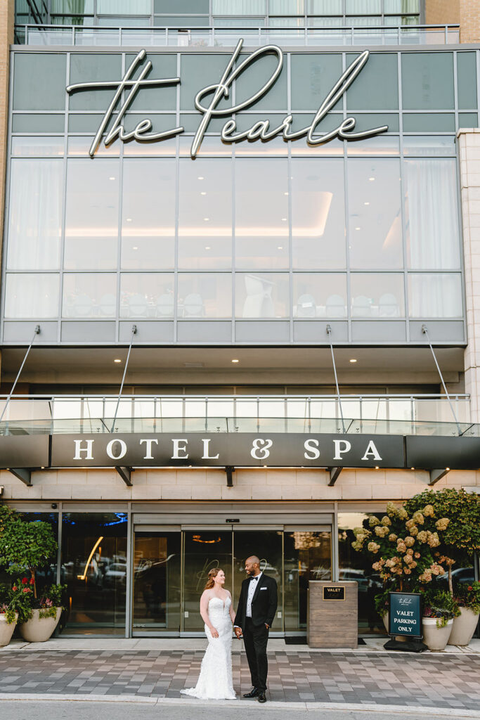 A bride and groom standing outside The Pearle Hotel