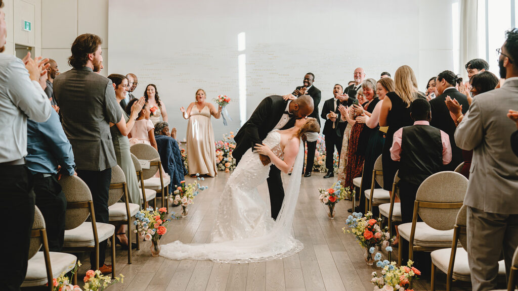 A dip kiss in the aisle at The Pearle Hotel