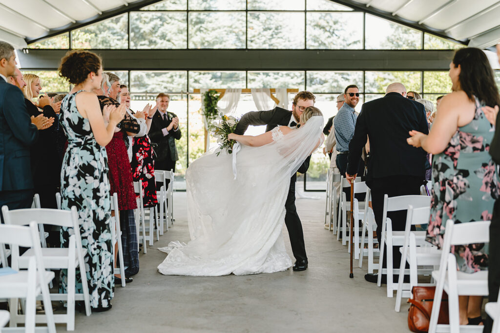A couple dip kissing in the aisle at a Garden Chapel ceremony at Whistle Bear wedding venue in Cambridge Ontario