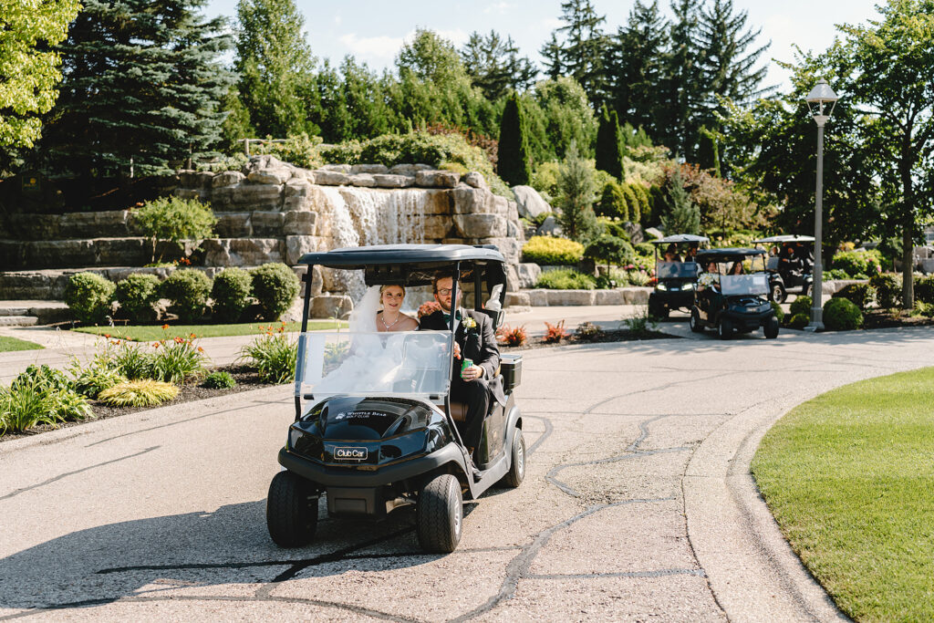 Newlyweds driving a golf cart at whistle bear