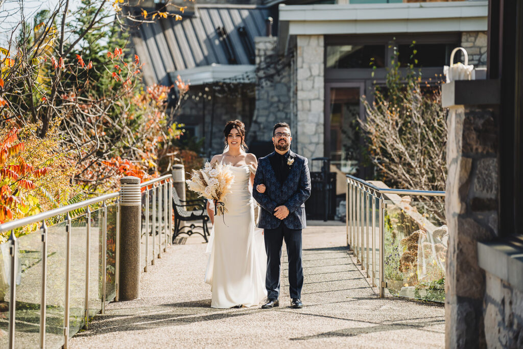 A bride and her father waiting to walk down the aisle at Cambridge Mill