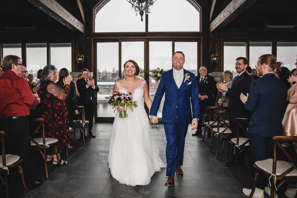 A couple walking up the aisle after getting married at Cambridge Mill