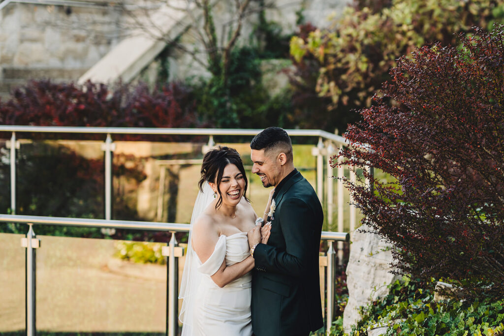 A wedding couple laughing at Cambridge Mill