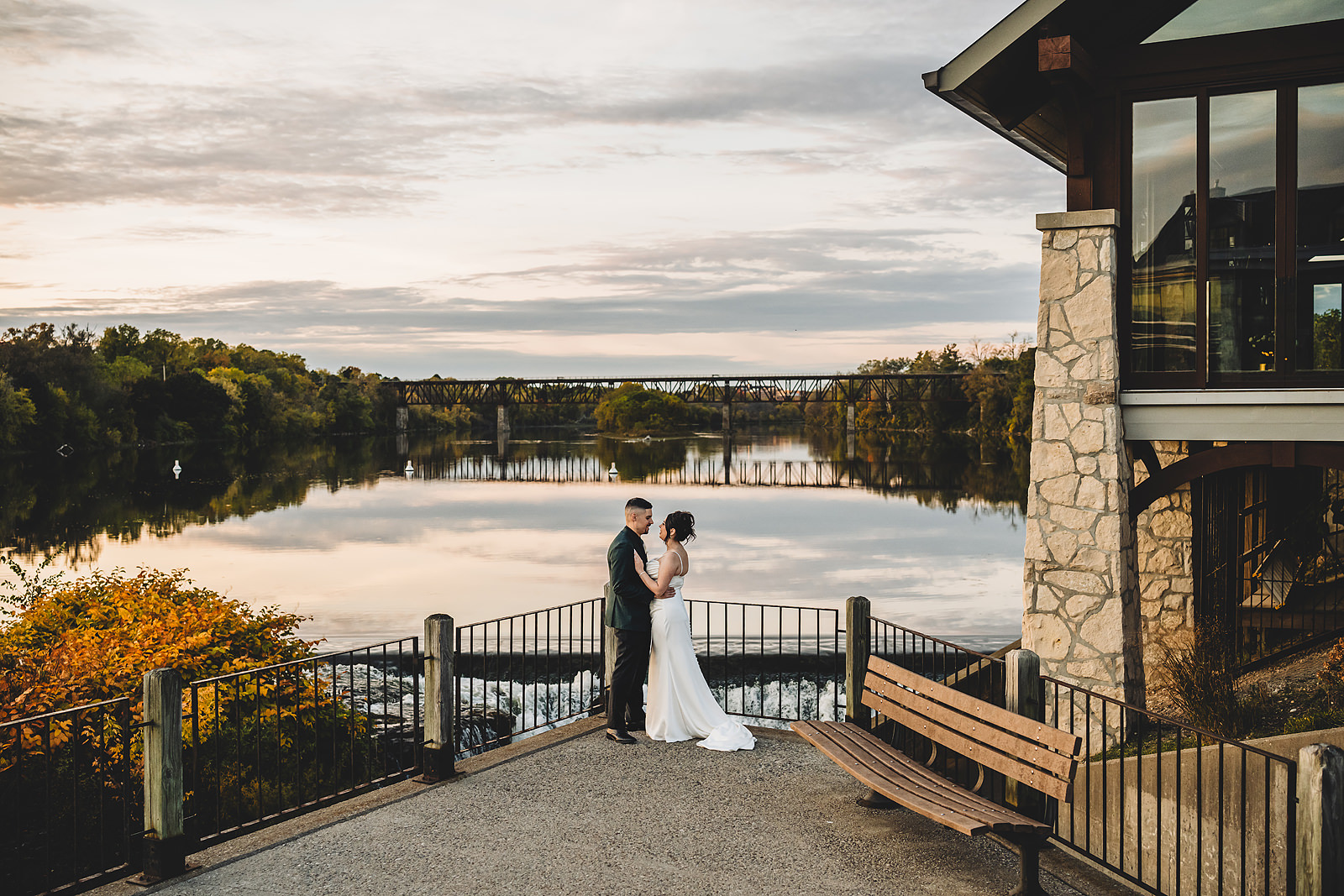 A wedding portrait against the Grand River at Cambridge Mill