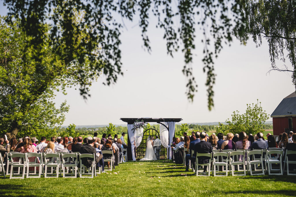 An outdoor wedding ceremony at the The Earth to Table Farm wedding venue