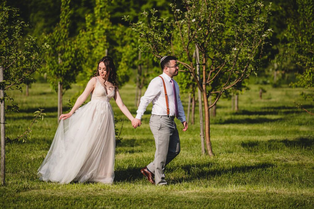 Newlyweds among the apple trees at The Earth to Table Farm wedding venue
