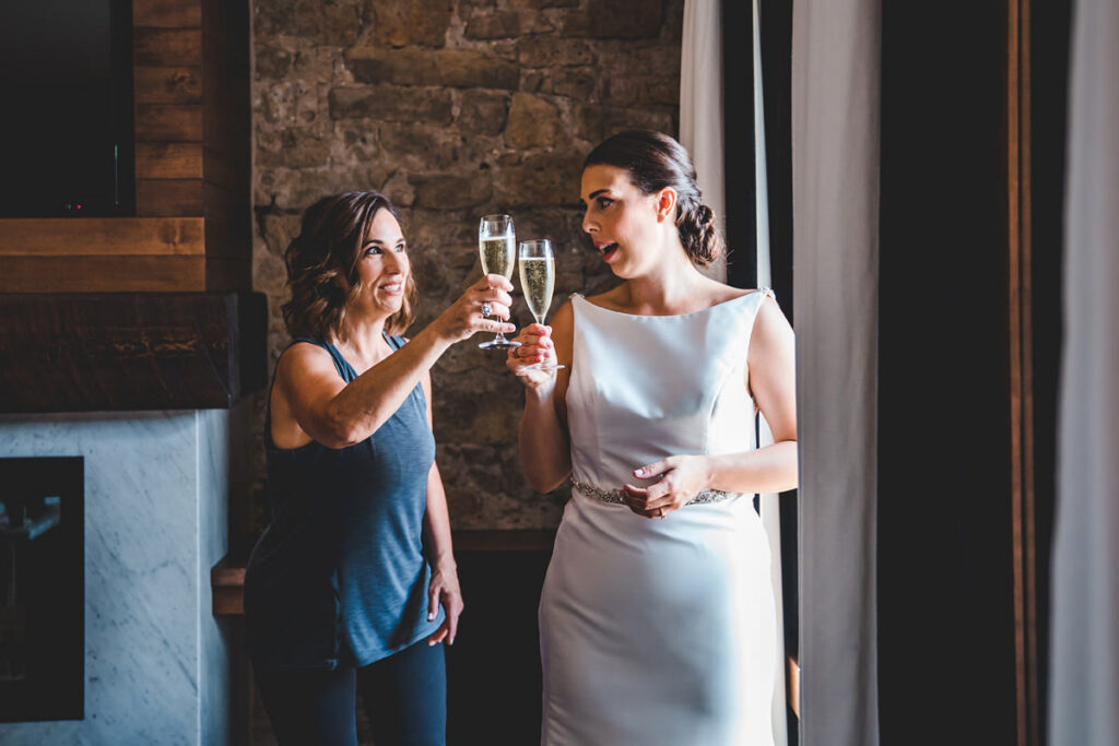 A bride with her mum celebrating and getting ready at Elora Mill