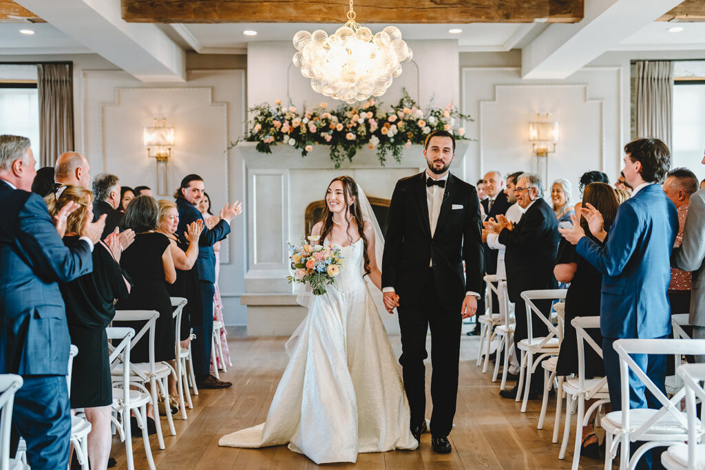 Newlyweds walking down the aisle at Elora Mill, Ontario