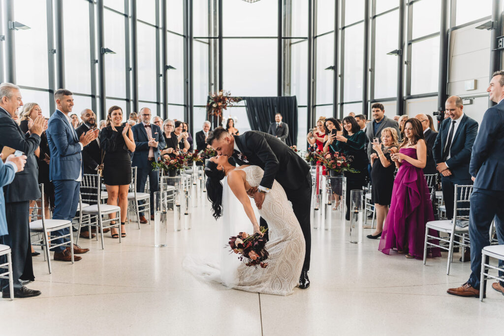 A dip kiss in the aisle at a Spencer's at the Waterfront Wedding